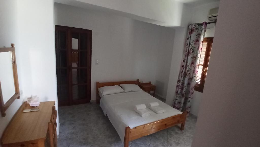 a small bedroom with a bed and a table at Genos suites in Stavros