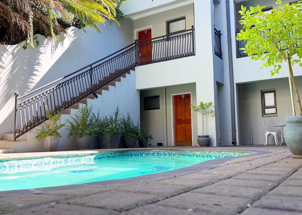 a swimming pool in front of a house at African Sands Guesthouse in Bloemfontein