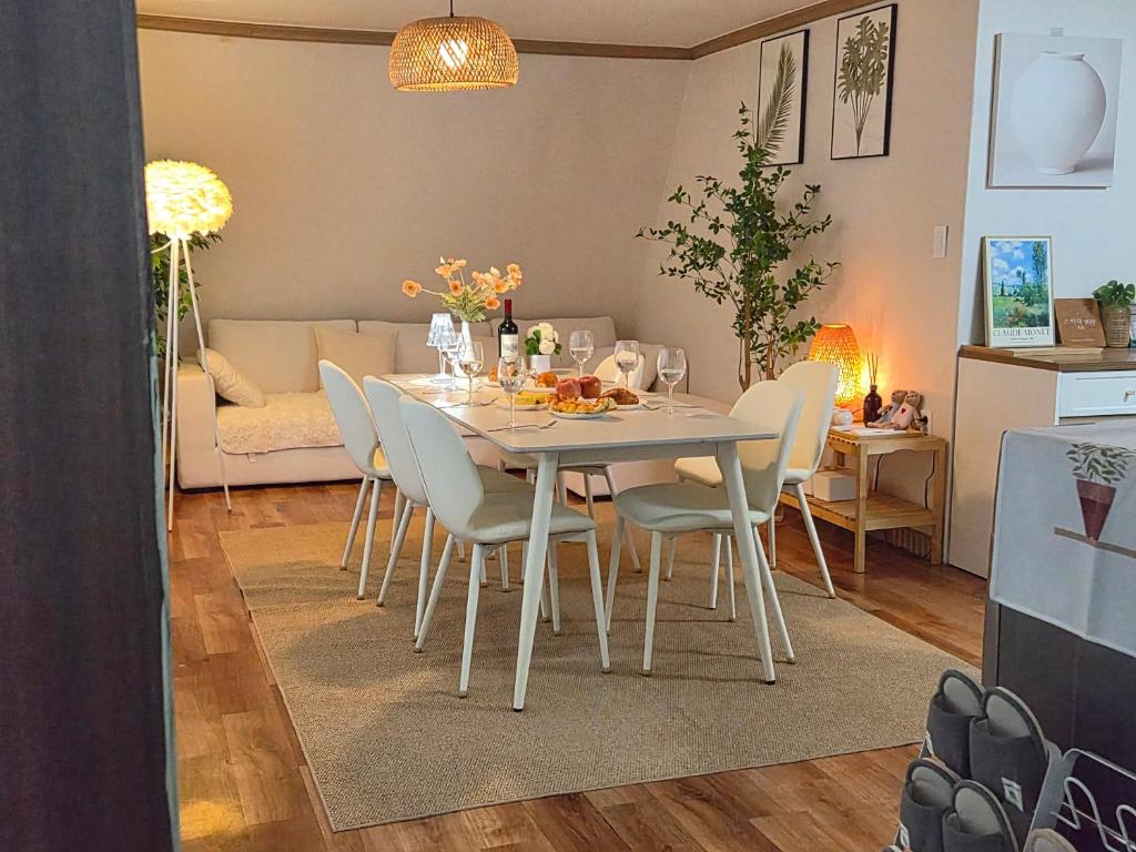 a dining room and living room with a table and chairs at 스미다 stay in Bucheon
