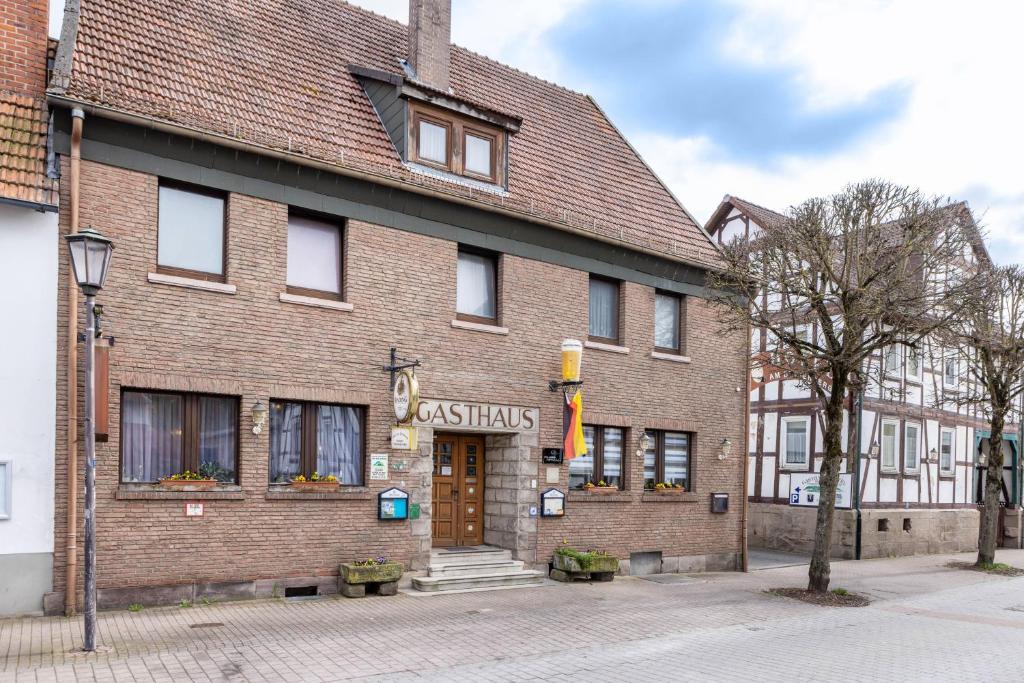 a brick building with a sign that reads asiasias at Gasthaus, Hotel am Dreienberg in Friedewald