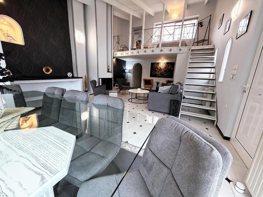 a living room with chairs and a table and a staircase at Natalie Apartments Athens Airport in Artemida