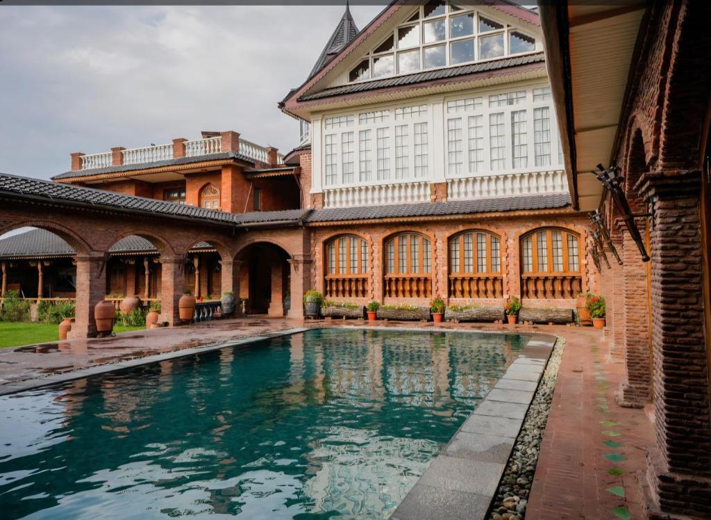 a house with a swimming pool in front of it at Hazaar Dastaan Kashmir in Srinagar