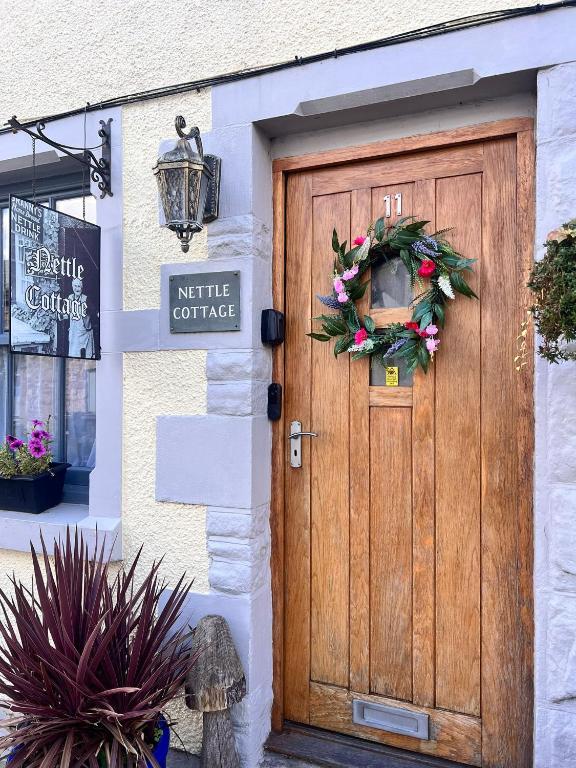 a wooden door with a wreath on it at Nettle Cottage in Heysham