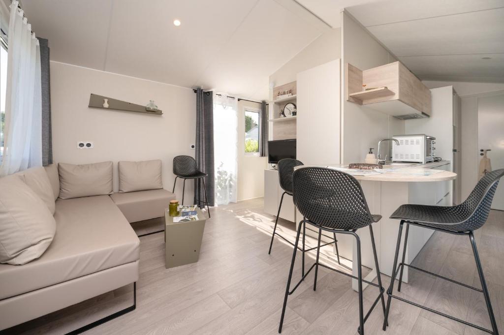 a living room with a couch and a table and chairs at La Brisse d'Erdeven in Erdeven