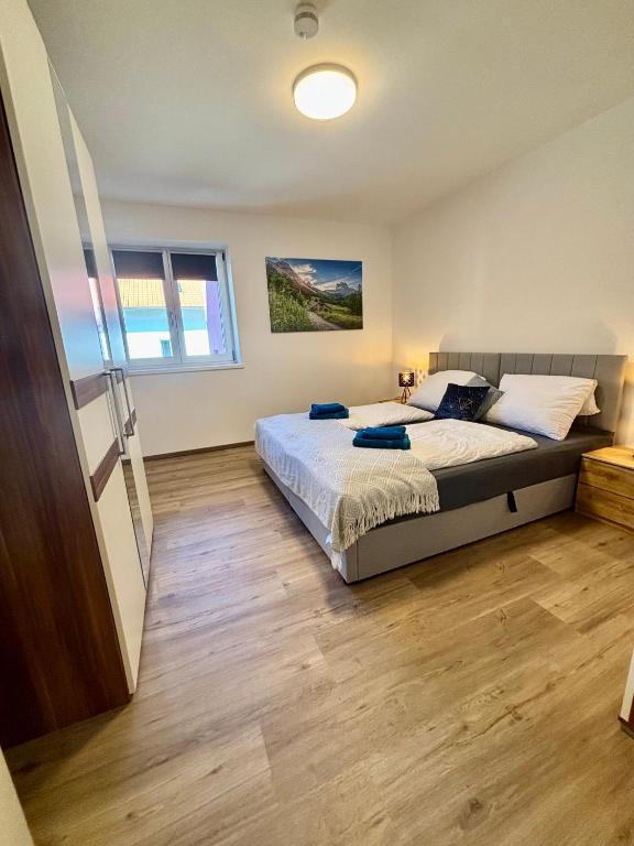 a bedroom with a bed and a wooden floor at Uii Apartments Oberaudorf in Oberaudorf