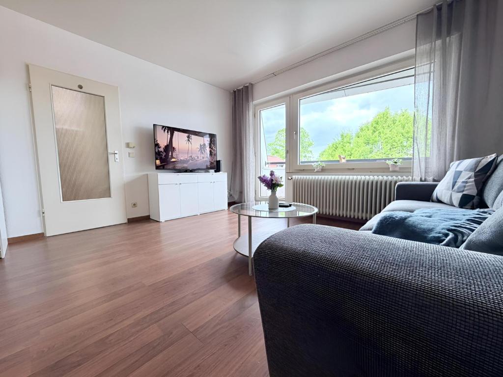 a living room with a couch and a tv at Über den Dächern von Borghorst - direktes Zentrum in Steinfurt