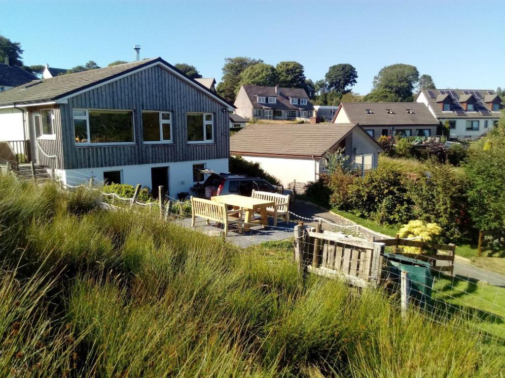 a house on a hill with a table and benches at Lyndale in Tobermory