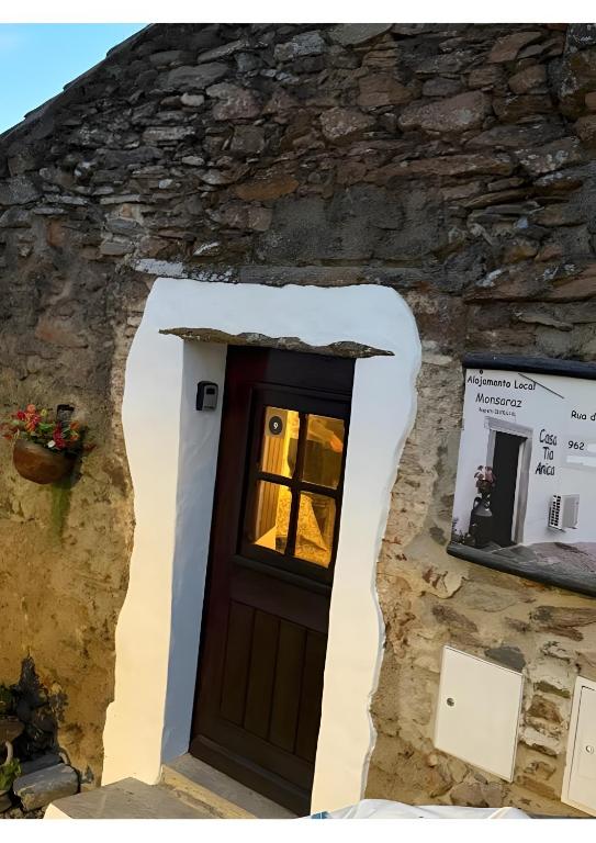 a door in a stone building with a window at Casa Tia Anica I in Monsaraz