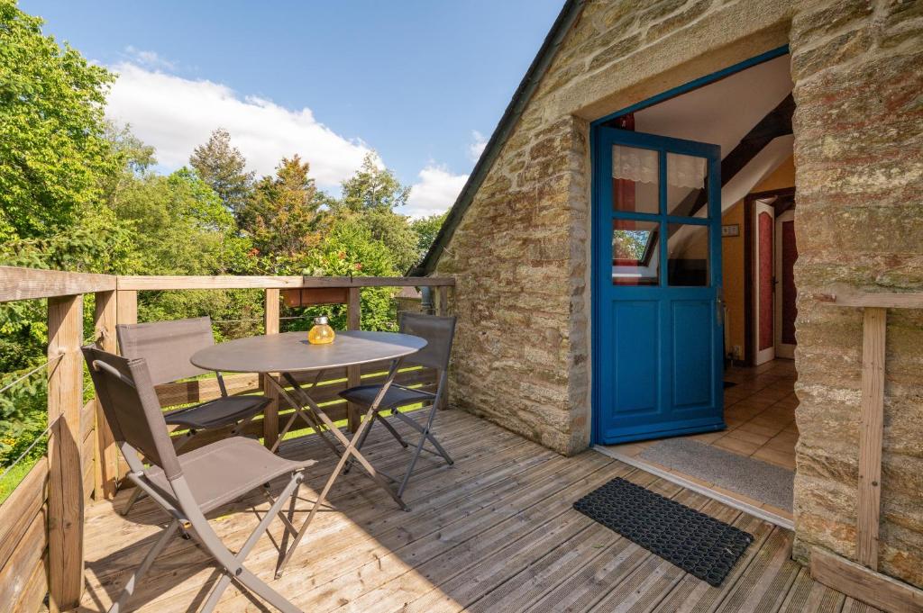 a patio with a table and chairs and a blue door at Gîte Nautilus in Elven