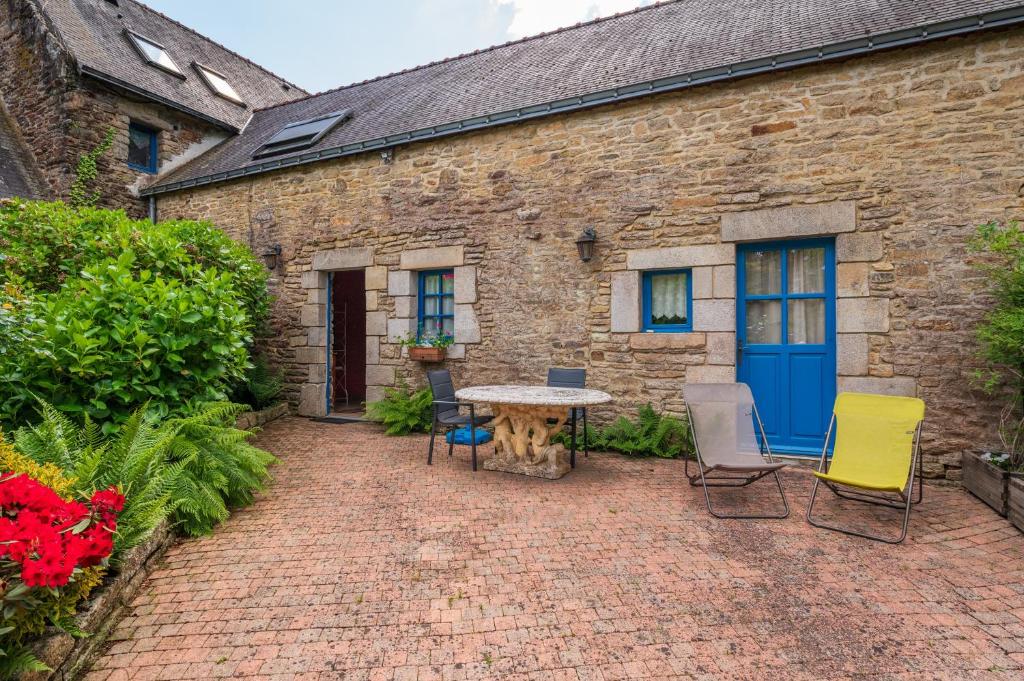 a patio with chairs and a table in front of a building at Gîte Peigne De Vénus in Elven