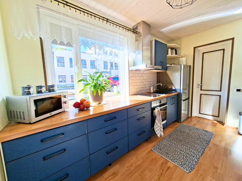 a kitchen with blue cabinets and a microwave at Meie Hiiumaa majutus Kärdlas in Kärdla