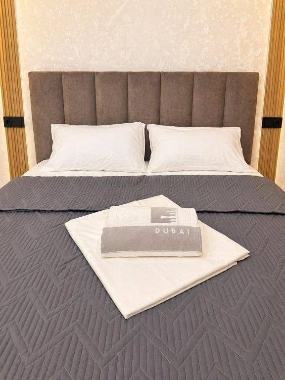 a book on a bed with a sign on it at Olympic Park Apartments near Almaty Arena in Almaty