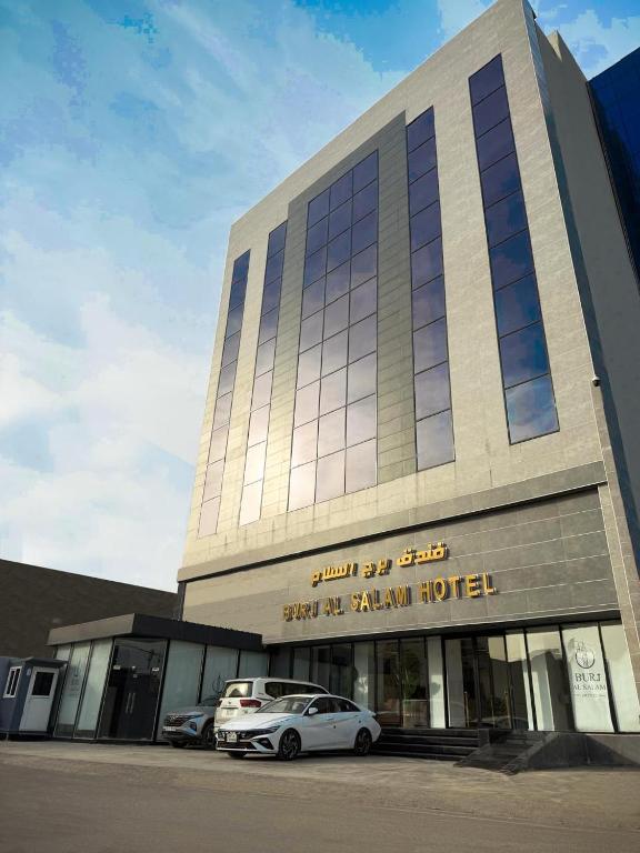 a building with cars parked in front of it at Burj Al Salam Hotel in Al ‘Alwīyah
