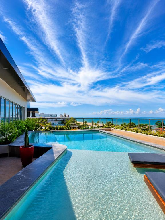 a swimming pool with a view of the ocean at W Tambaú Apart Hotel in João Pessoa