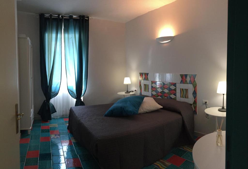 1 dormitorio con 1 cama y 2 ventanas con cortinas azules en Via Roma 205, en Rionero in Vulture