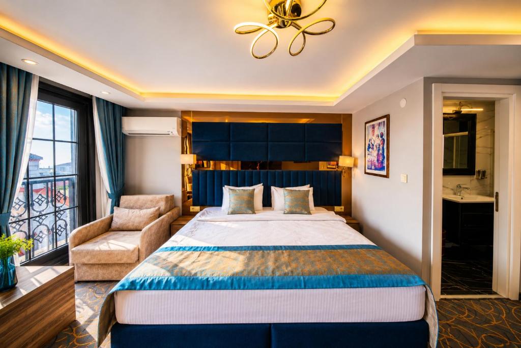 um quarto de hotel com uma cama grande e uma cadeira em Kavi Hotel em Istambul