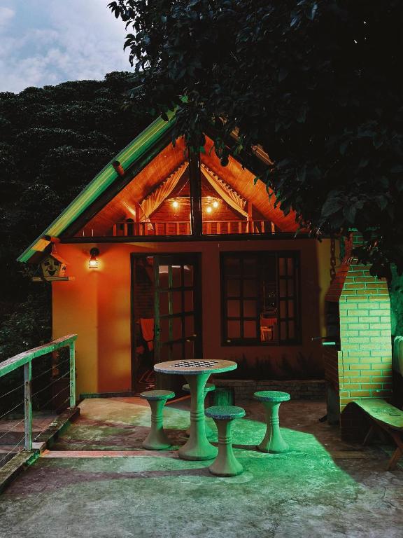 a small house with a table and chairs in front of it at Bangalo Bela Vista in Caparaó Velho