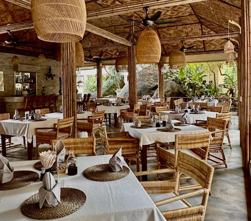 a restaurant with white tables and chairs and ceilings at Röstiland by NOXAMA SAMUI in Lamai