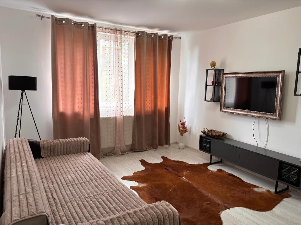 a living room with a couch and a television at City Comfort Apartment in Bacău