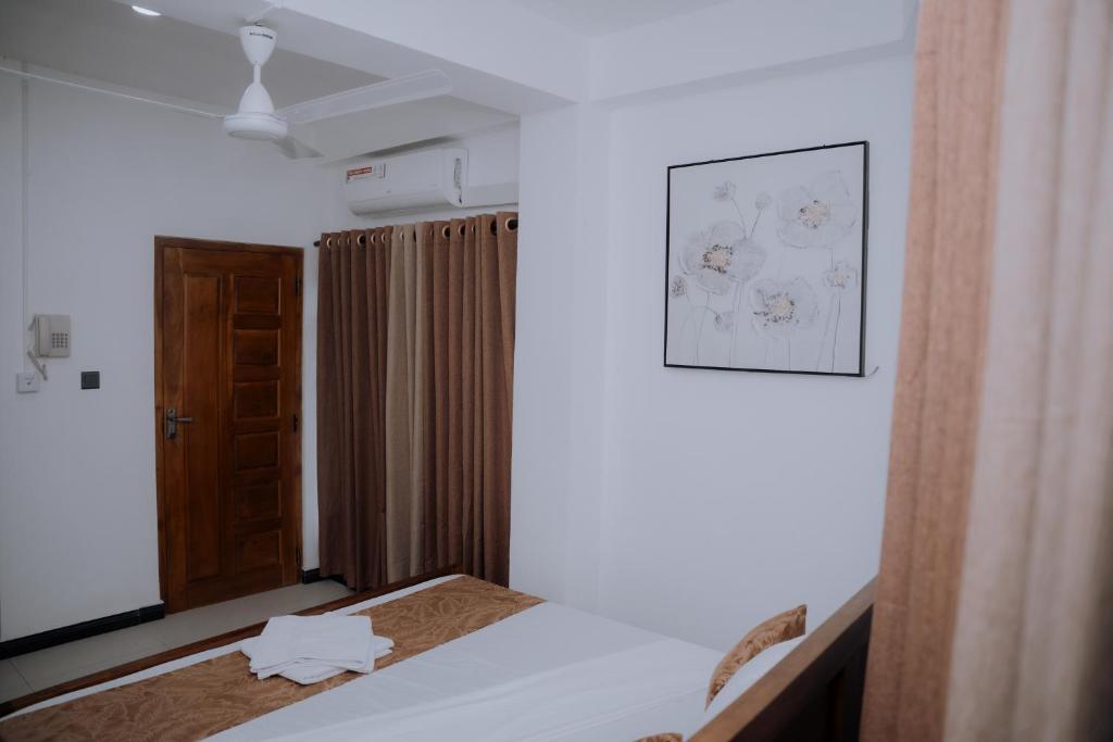a bedroom with a bed and a picture on the wall at Blue9 Hotel in Jaffna