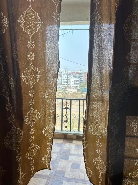 a view of a balcony from a window with curtains at Suyakshi homestay in Pune