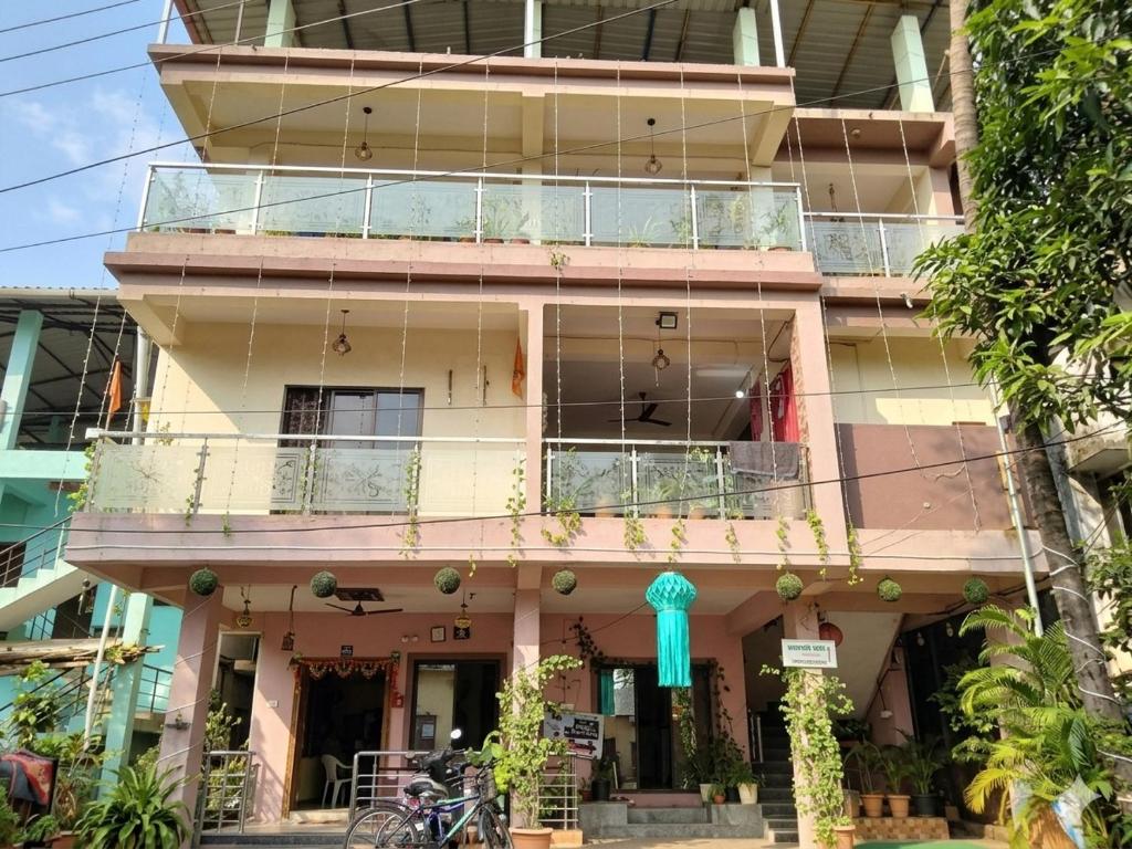 a building with a balcony in front of it at Green Didis Cottage in Nagaon