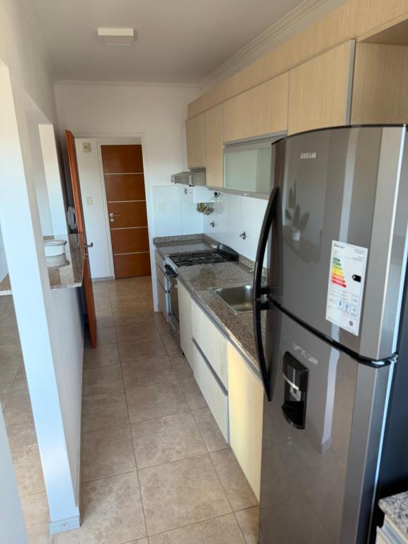 a kitchen with a refrigerator and a sink in it at LuxApart in Caleta Olivia