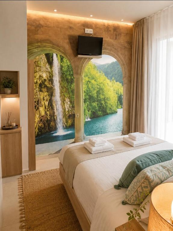 a bedroom with a large bed with a waterfall window at Hostal Bernareggi in Cala Figuera