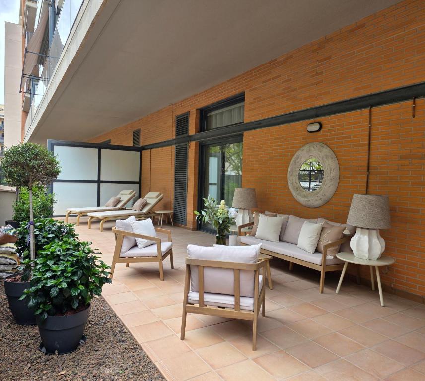 a patio with couches and chairs on a brick wall at MD Valterna Suites & Pool in Paterna