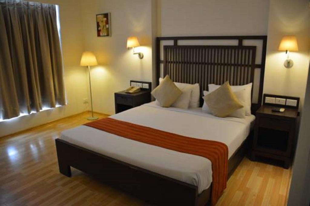 ein Schlafzimmer mit einem großen Bett und zwei Lampen in der Unterkunft Hotel Natraj in Dibrugarh