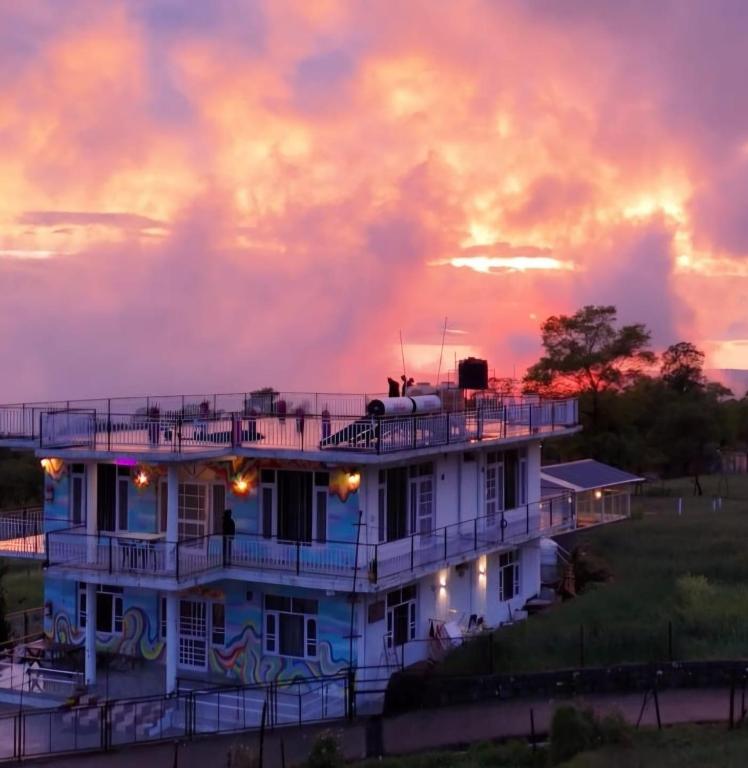 a white house with a sunset in the background at The Bunksters Bir in Bīr