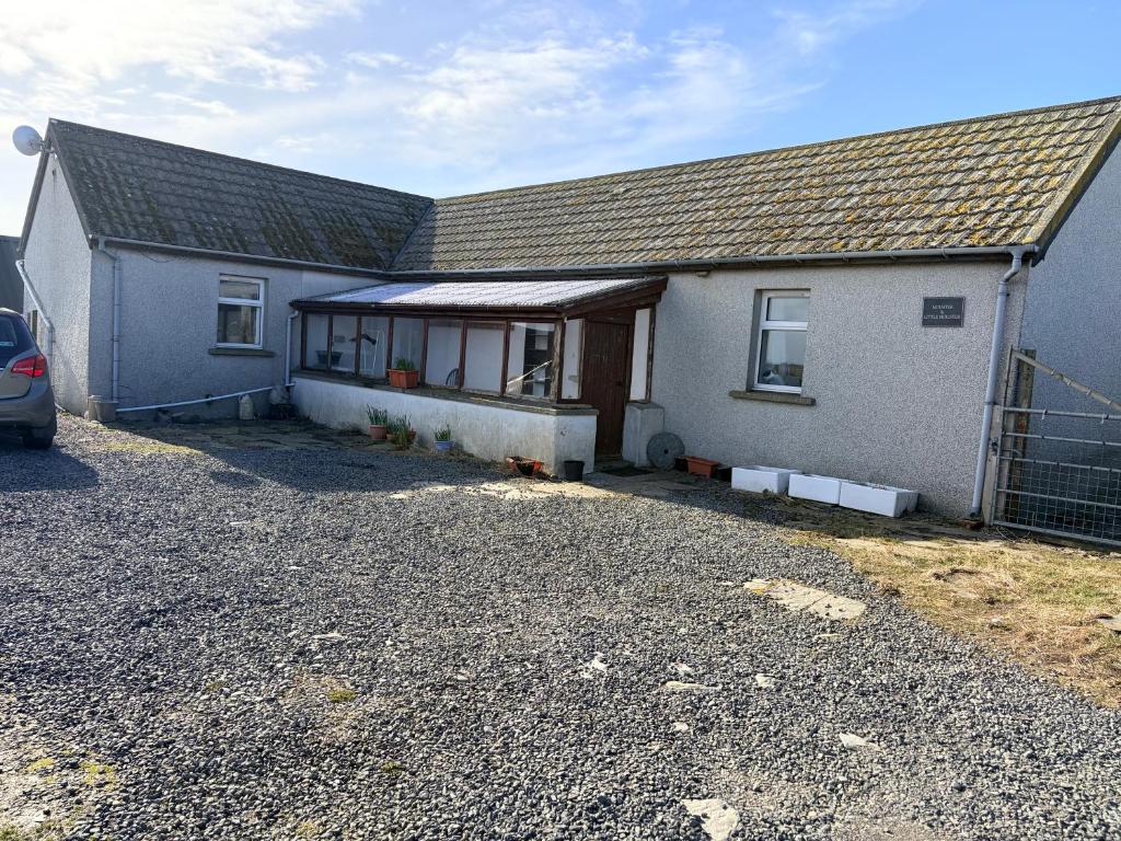 a house with a car parked in front of it at Accommodation by the sea on Sanday in Orkney