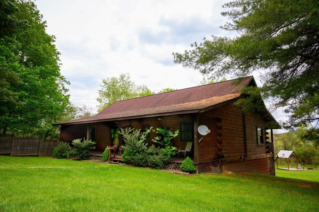 a small wooden house with a grass yard at Rustic Way in McArthur