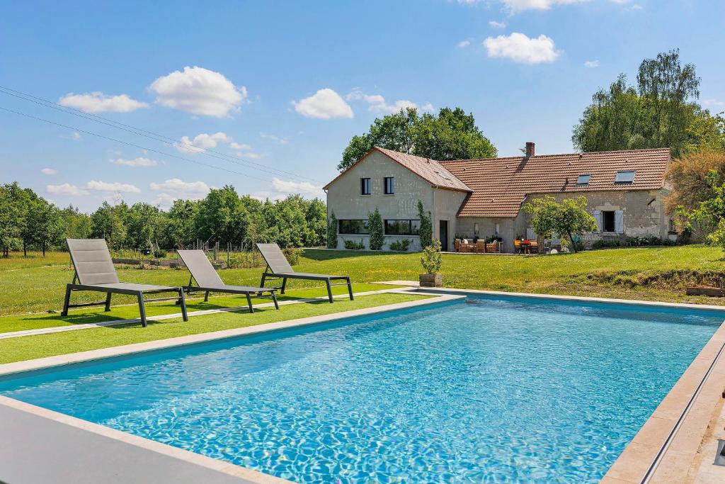 a swimming pool with two chairs and a house at Maison de la Gentinière Zoo Beauval in Mareuil-sur-Cher