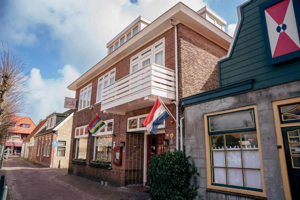 a building with flags on the side of a street at Hotel Oepkes in West-Terschelling