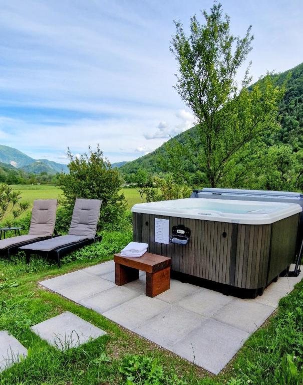 a hot tub with a bench and two chairs at Apartment House Blazar in Tolmin