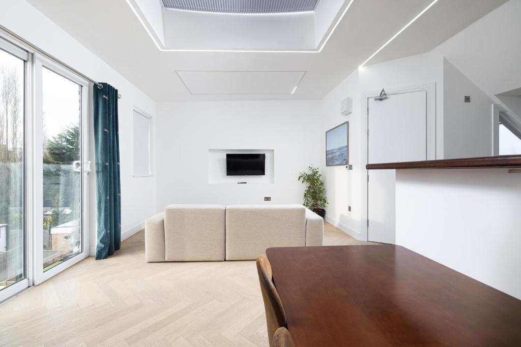 a living room with a couch and a table at Harrow Boutique Suites in Harrow
