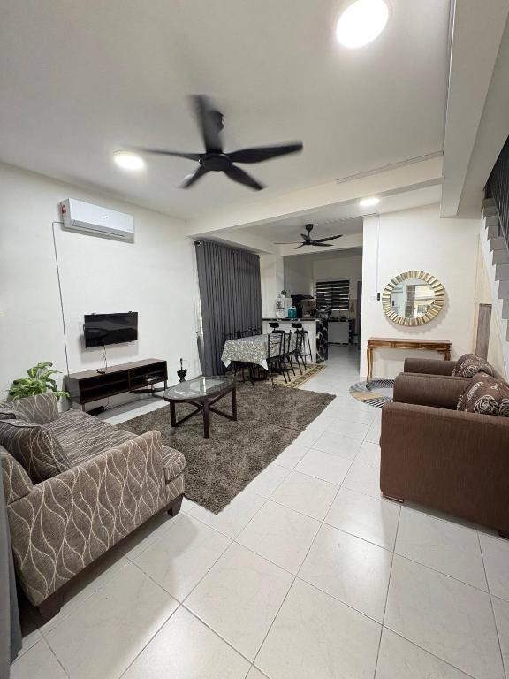 a living room with couches and a ceiling fan at Arowana Homestay MALAY ONLY in Sungai Petani