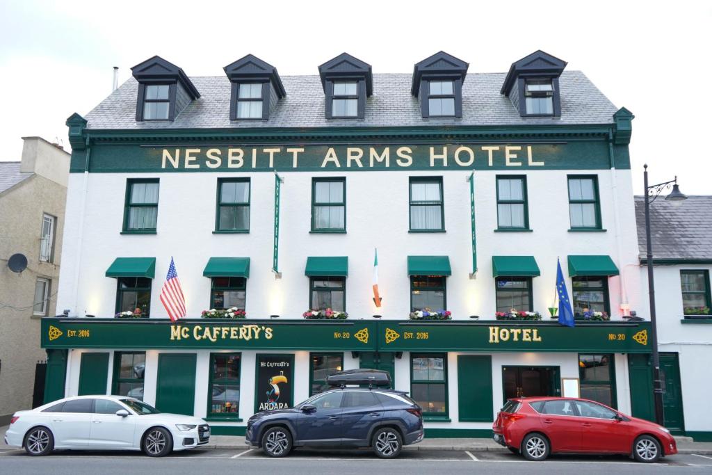 a hotel with cars parked in front of it at Nesbitt Arms Boutique Hotel in Ardara