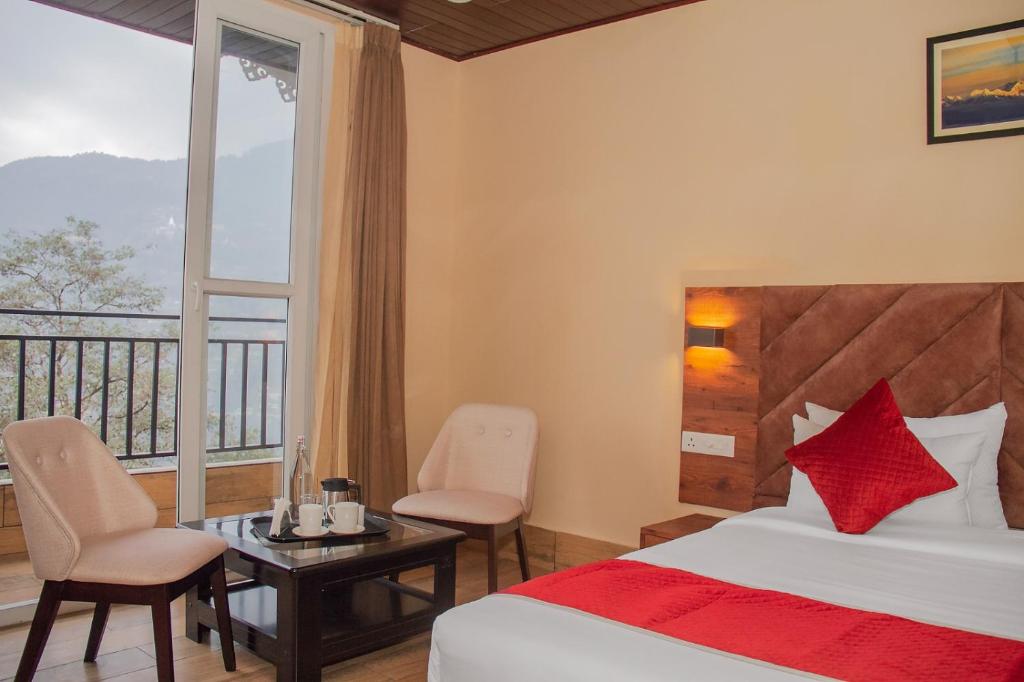 a hotel room with a bed and a balcony at The Kashyap Castle in Gangtok