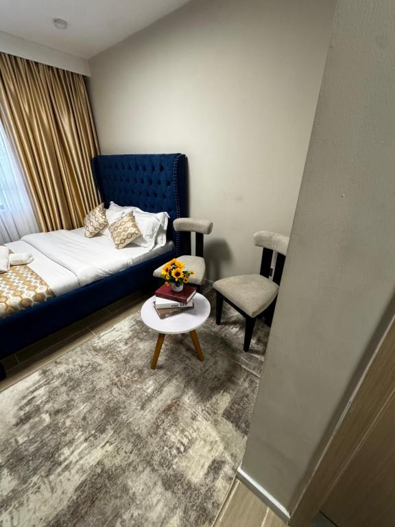 a room with a bed and a table and a chair at ZIVA HOMEs 2 in Marimbeti