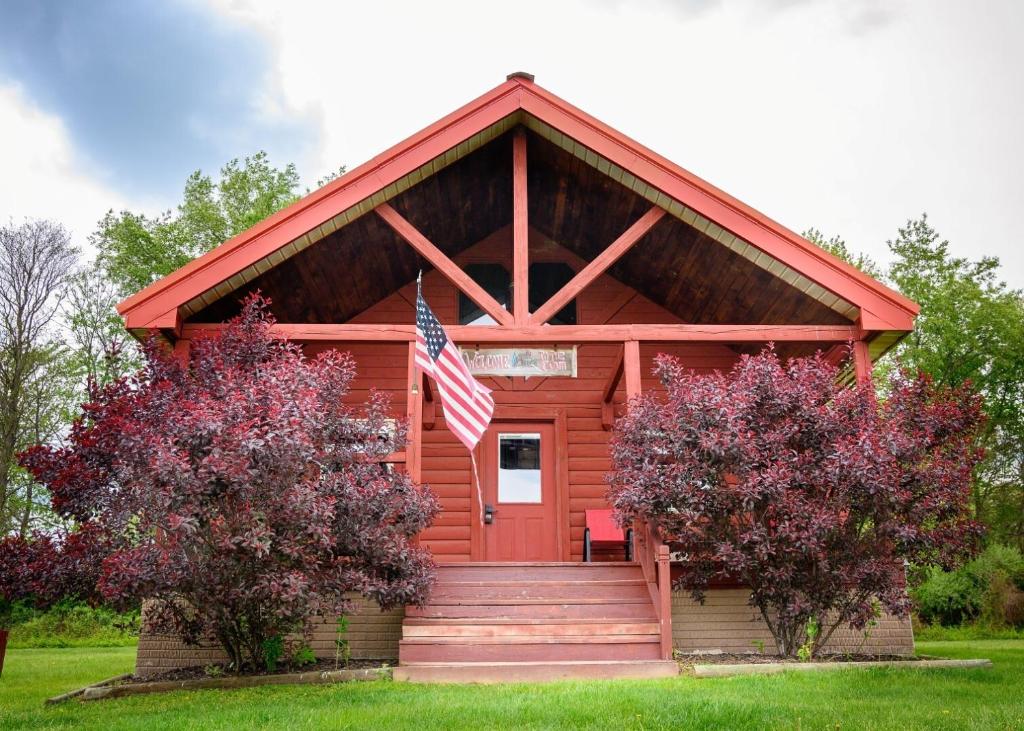 a red cabin with an american flag on it at Fisherman’s Dream in McArthur