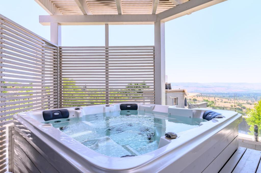 a hot tub on the balcony of a building at ציפור הכנרת - סוויטה מבודדת נוף לכנרת in Had Nes