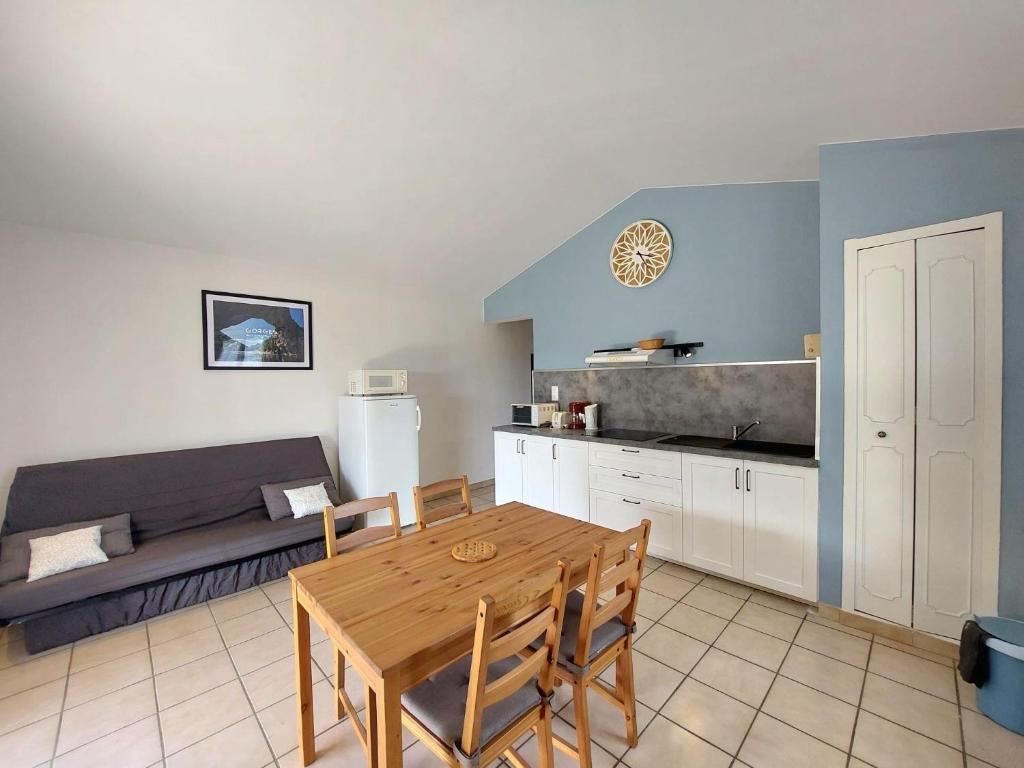 a kitchen and dining room with a table and a couch at Le Cyprès - La Fontinelle in Bessas