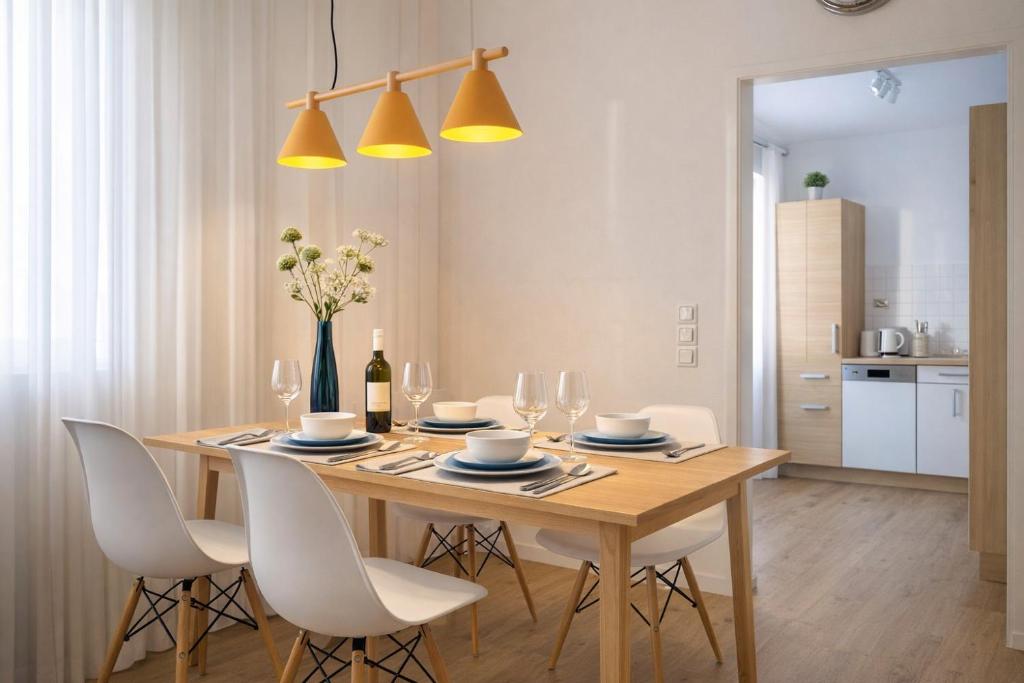 a dining room with a wooden table and white chairs at APSTAY central station I Self Check-in I Parking option in Graz