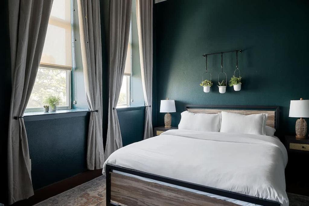 a bedroom with a large bed and a green wall at Cute Little Condo no 310 in Dallas