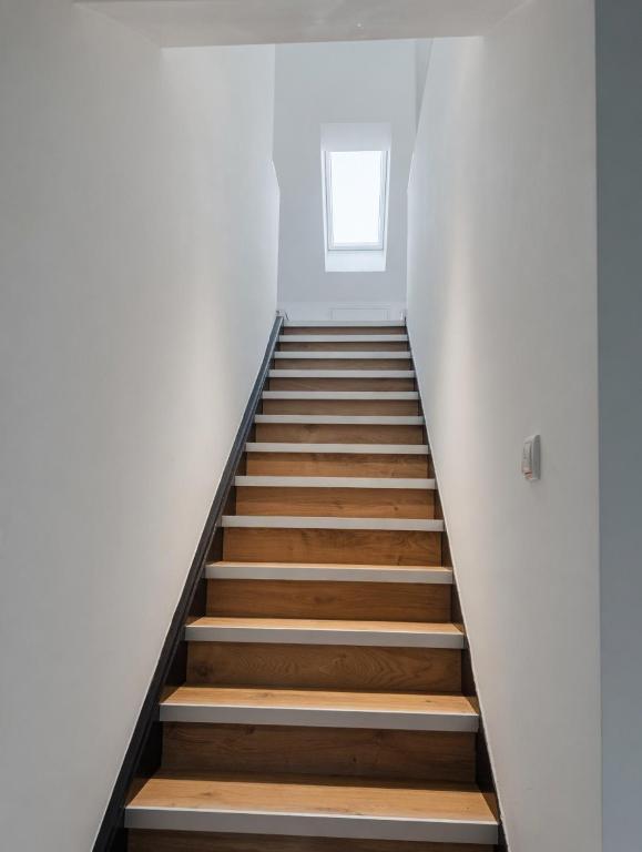 a staircase in a white room with wooden floors and a window at Monteur Zimmer Künzing in Künzing