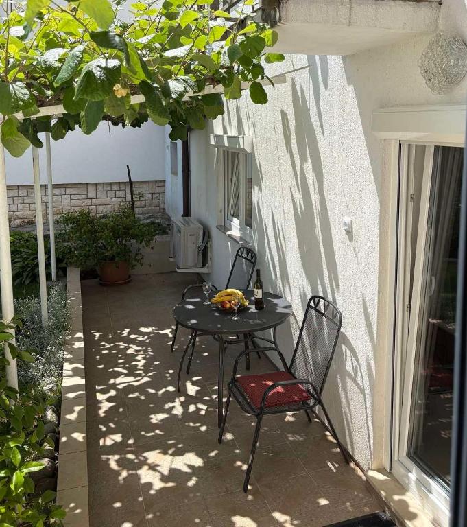 a patio with a table and chairs on a patio at Apartman Aurora in Ičići