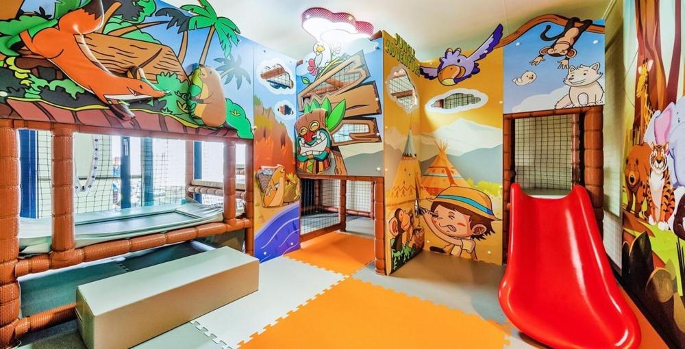 a childrens play room with a red slide at Daebudo sunshine kids poolvilla in Ansan