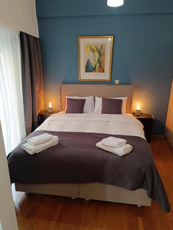 a bedroom with a large bed with two towels on it at Thissio Hideaway Suite in Athens